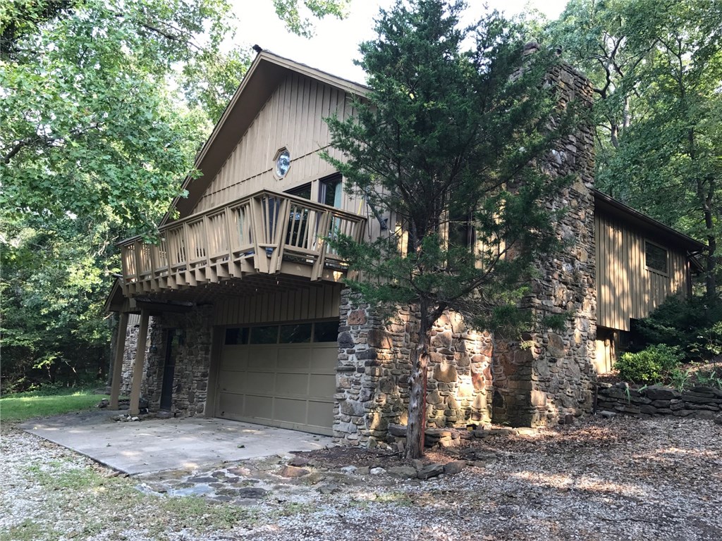 Lake area & 3 acres. Seller can owner fin 2 more acres. Seller to give Buyers $5000 for updating. Large open floorplan. A lot of house & land for only $76 sq ft. New roof installed. 1870's Antique wooden arched entryway from German tavern. 2 bedrooms are upstairs on the main level.  One huge bedroom/office/game room downstairs off the garage. Curved natural rock staircase leading to the main level. 8 ft rock wood burning fireplace. Antique dumbwaiter in the kitchen to send snacks downstairs.