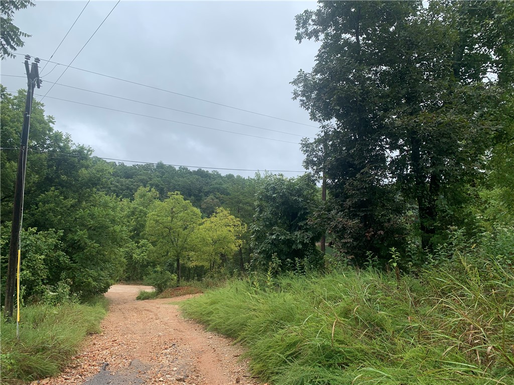 Motivated Seller!! Packed with potential! Discover 4.74 acres of opportunity with lake view and a convenient public boat launch just across the street! This property is ready for your vision, whether you're looking to build your dream home or create a private retreat. Land is fully useable with several flat buildable areas. Key features: Septic, public water, and electric already available, 30x32 insulated metal garage building, and 4 RV hookups for guest or family gatherings. The manufactured home conveys with property in "as is" condition. Don't miss your chance - come take a look and bring us an offer!