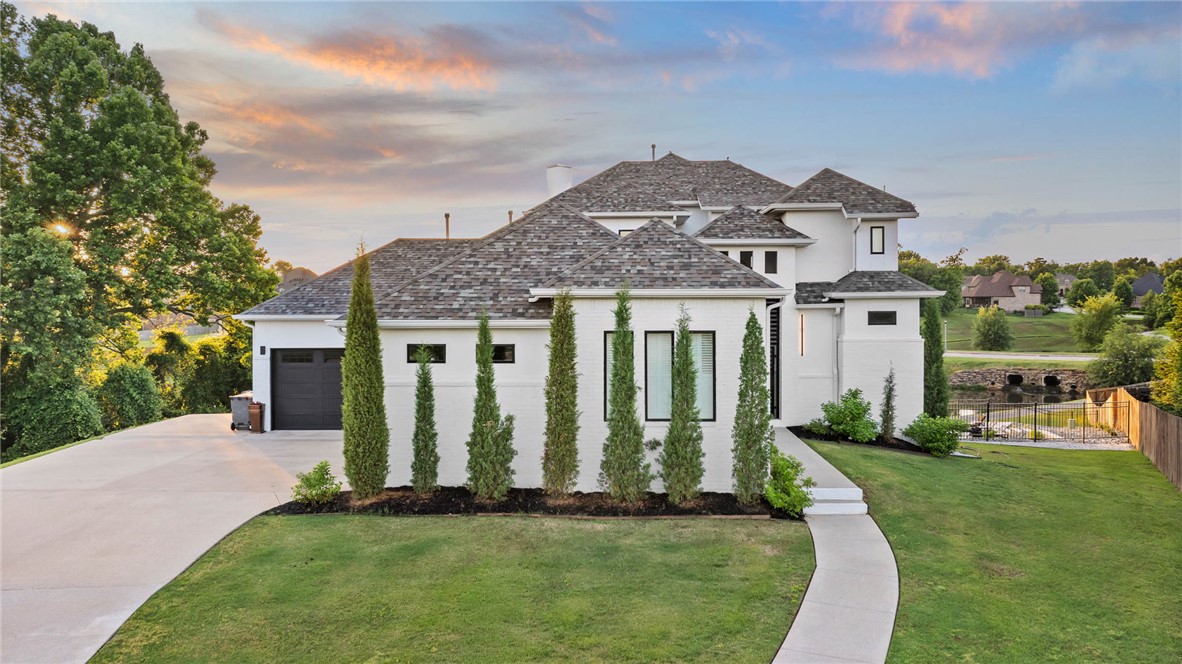 If you are looking for a home that will truly WOW you, this is it! Designed with both connection and space in mind, this 5 bed 5.5 bath home offers multiple living areas across all levels, creating the perfect balance for gathering and privacy. The main level features a spacious living area, half bath for guests, a private primary retreat, and an additional suite with its own entry, ideal for guests or multi generational living. Upstairs offers 2 BD/ 2BA and a flexible bonus space, while the walkout basement creates the ultimate hangout with a full bar, gym area, bed, and bath. Step outside to a resort style setting complete with a stunning infinity edge pool overlooking the water and multiple patios designed for hosting, relaxing, and enjoying the view. Don't miss the workshop area/garage! Thoughtfully laid out and full of possibility, this home is built for the way people truly live, in one of the area’s most desirable locations just minutes from Rogers/Pinnacle, and less than 20 minutes to Downtown Bentonville.