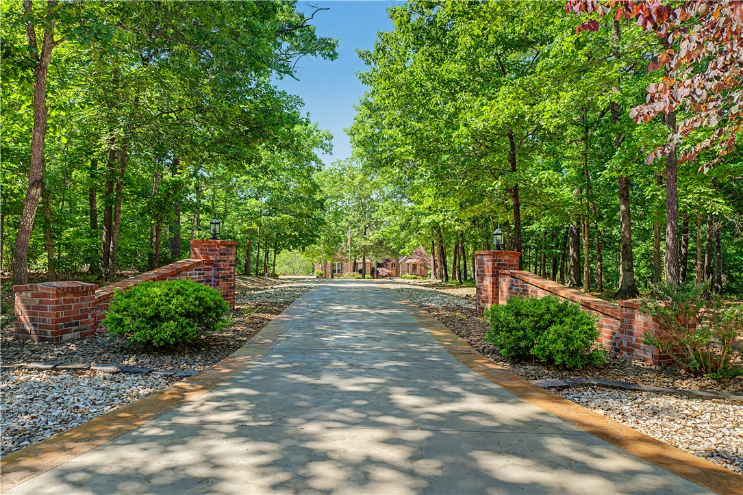 Tucked away on nearly 8 pristine acres in Highlands Estates, this extraordinary custom estate redefines luxury living. Offering 3,999 square feet of grand design and timeless craftsmanship, this 4-bedroom, 3.5-bath masterpiece delivers the privacy, elegance, and presence rarely found in Bella Vista. A stately circular driveway welcomes you home, setting the tone for the impressive interiors featuring soaring ceilings, expansive living spaces, and upscale finishes throughout. The gourmet kitchen is designed to impress with granite countertops, a propane cooktop, and abundant space for entertaining. Every detail of this home was thoughtfully crafted to create a true estate feel rather than simply a home. The oversized 4-car garage provides exceptional storage and functionality, while the surrounding acreage offers unmatched serenity and room to breathe. Grand, private, and unforgettable—this is luxury living at its finest.