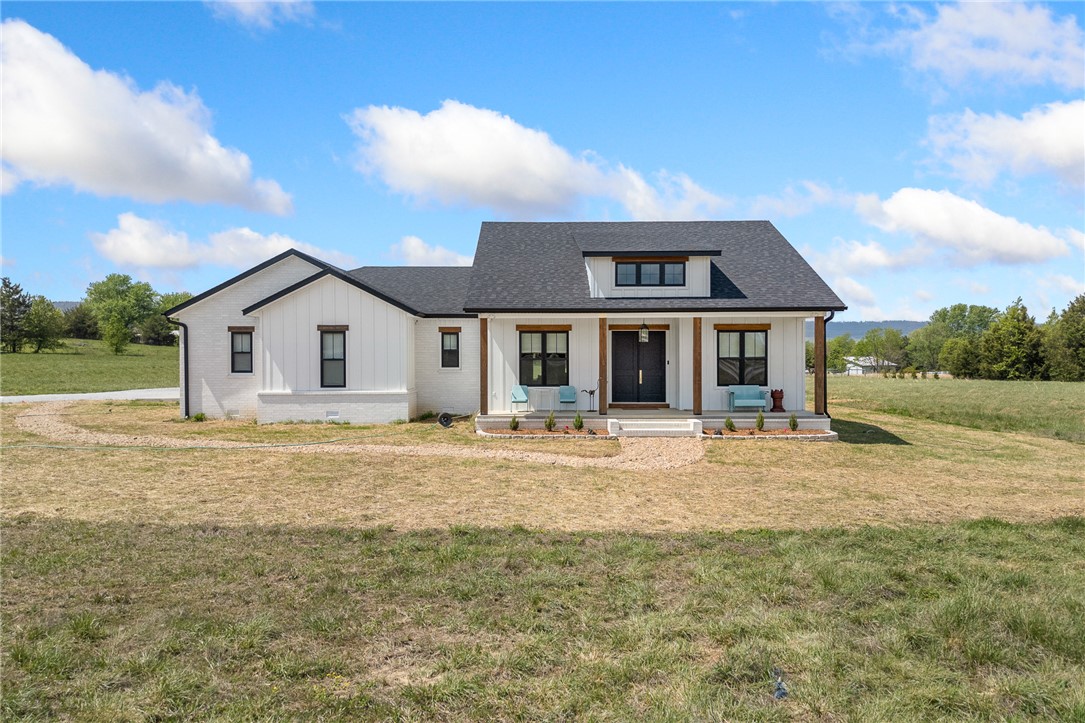 Set on 8.68 m/l acres this EXQUISITE 3/2 residence built in 2023 offers 2,148 sqft of refined finishes paired with a 2/1 800 sqft guest cottage and a pond!  The level of craftsmanship is evident...Mohawk wood flooring runs through the main living spaces, complemented by travertine tile in all the right places. Black vinyl windows frame the home’s clean lines and white brick exterior—authentic, not painted!  A dream kitchen featuring a quartz island, soft-close cabinetry, top of the line appliances and a walk-in pantry with 12 drawers and 20 shelves.  The primary suite is a retreat! The ensuite bath showcases a walk-in shower with a built-in bench and a layout that is elevated style. Want more? Hardwired generator,  water softener, whole-home filtration system, 3 ft wide doorways and a safe room built of concrete and steel.  Outdoor living is fabulous here - the back patio is plumbed for a hot tub and gas grill! The guest cottage: 2 BR, 1 BA currently operating as an Airbnb and will be sold fully furnished.