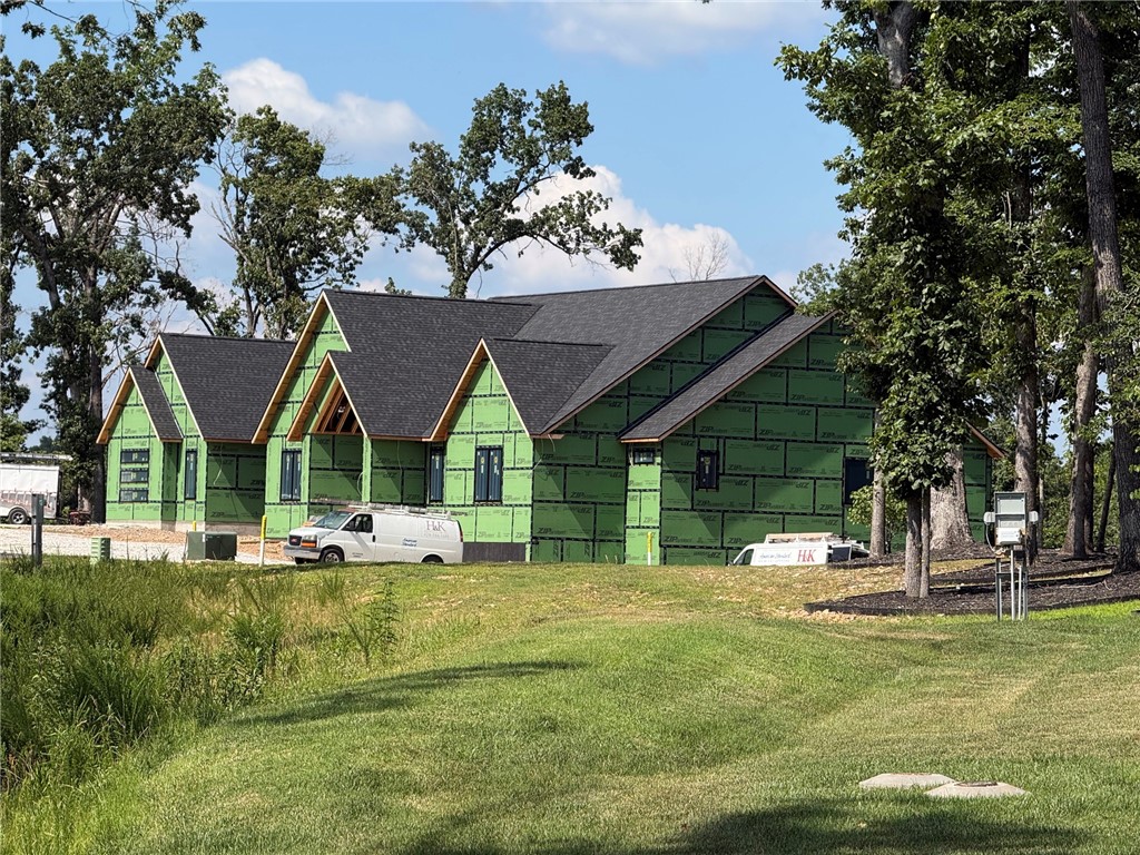 Tucked into a wooded setting just minutes from the best of Bentonville, this 6,800 sq ft luxury home on 3 acres offers the rare blend of privacy and proximity—only 1 mile to the new Walmart Campus and upcoming medical center, 2 miles to the Bentonville Square, and quick access to I-49. Vaulted ceilings draw you through the main living space to an expansive upper deck overlooking a stunning resort-style pool framed by mature trees. The kitchen is a showpiece with white oak cabinetry in a walnut stain, integrated refrigerator, 48” gas range, and a walk-in pantry built for real use. The main level features a private office, guest suite, and a serene primary retreat with a spa-inspired bath, European wet room, and direct deck access. The lower level is built for entertaining with a second kitchen, pool bath, game room, and flexible bedroom spaces—all opening to your private outdoor escape. Crafted by a 3rd generation local builder. Customize the finishes today!