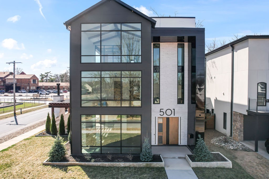 Experience luxury living in the heart of downtown Bentonville with this modern masterpiece. No expense has been spared in this stunning home.  This custom design features an open floor plan and an abundance of natural light from floor to ceiling glass including 37 feet of vertical clerestory windows. Situated on a corner lot with professional landscaping, this home is just steps away from Bentonville Square, Crystal Bridges Museum, and scenic bike trails. Other features include a floating staircase with hickory treads spiraling around 3 floor elevator, a four-inch walnut pivot door, Chef’s kitchen outfitted with exquisite materials, Dacor appliances, wine tower, hidden fridge and freezer, Bosch coffee station and a full prep kitchen. The owner’s suite offers a private full floor retreat with dedicated laundry, soaking tub, and a hot sauna and steam room. The property includes a full garage house with 2 bedrooms, 2 baths, a living area, and an additional outdoor living space.  This is 1000+ additional sq ft.