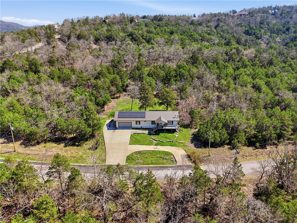 Welcome to Holiday Island! 1500+square feet, 3 bed, 2 bath, One Level home, sitting on a 1/2 acre.  AC system installed in 2020.  New metal roof and gutters in 2024. Solar Panel system for more efficient utility bills.  This home offers a friendly floor plan, along with an attached 2-car garage. Two Driveways allows plenty of space for multiple vehicles.  Backyard is beautiful and open, with a firepit! Allowing for lots of fun time!  Minutes from the community pool, marina, lake and golf courses! And of course, Eureka Springs!