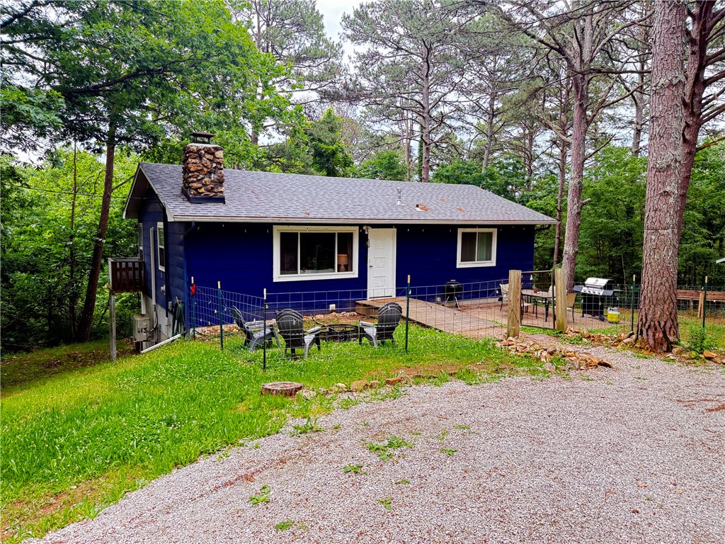 Secluded 2BR/1BA home on 5.86 acres just minutes from downtown Eureka Springs. Newly renovated main level with open floor plan. Stone wood-burning fireplace in the living room. An island separating the living and kitchen/dining areas. Two spacious bedrooms and a full bath with a tiled walk-in shower and double vanity.   An additional 960 square feet of unfinished space in a walkout basement with a concrete floor, windows, and a door to the backyard. Great space to finish out for more living or use as a workshop or studio.  Additional storage in an 8'x9' outbuilding. Fenced yard around the house for pets. Outside city limits, so it could be used as a short-term rental.