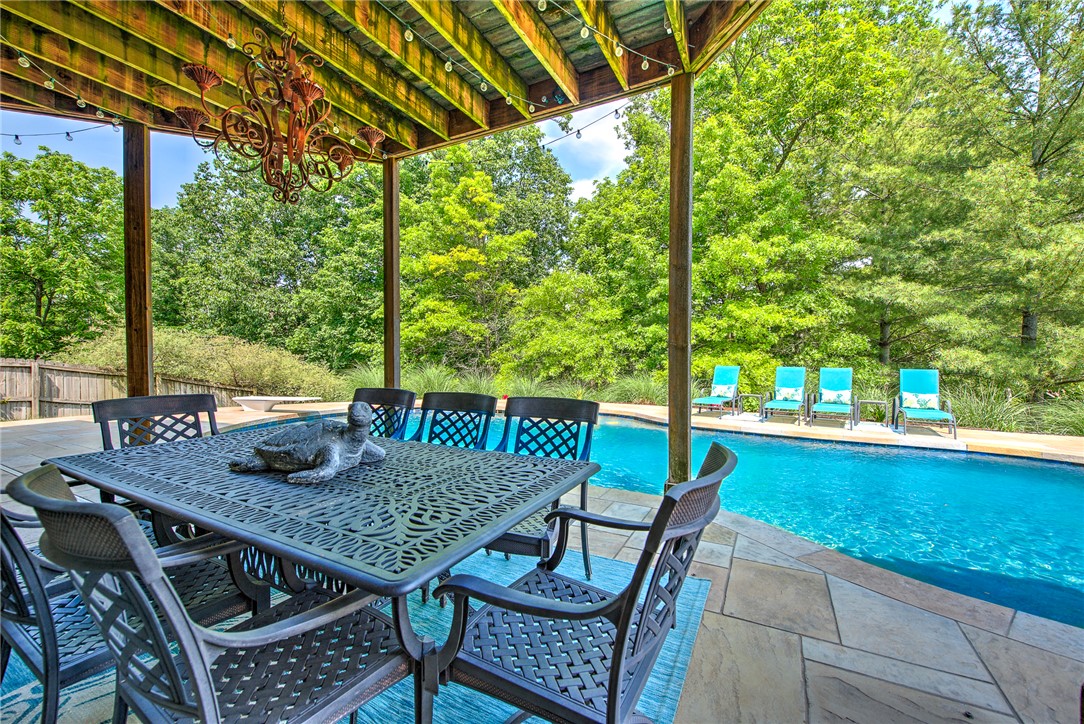 Luxury living meets everyday comfort in one of Bentonville's most convenient locations. Just minutes from Downtown Bentonville, the Walmart Home Office, Crystal Bridges, premier schools, and I 49, this beautifully designed home offers over 4,400 square feet of flexible living space with a heated in ground pool, walk out basement, and private backyard built for year round entertaining. The open concept main level is filled with natural light and features hardwood flooring, spacious living areas, a well appointed kitchen, and a luxurious primary suite. Downstairs, the fully finished walk out basement creates the perfect space for guests, multigenerational living, recreation, or a private home office. Outside, enjoy expansive patios, mature landscaping, and a resort style backyard rarely found this close to the heart of Bentonville. With five bedrooms, four bathrooms, multiple gathering spaces, and exceptional indoor-outdoor living, this home offers the space, location, and lifestyle today's buyers are searching for.