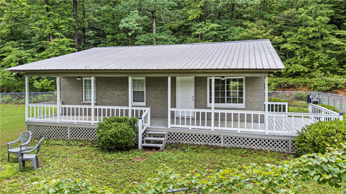 Turnkey, fully furnished, cabin-style home! Property conveys with furnishings, offering a move-in ready or investment-ready opportunity with modern rustic finishes. This home includes 3 bedrooms, 1 bathroom and a covered, wrap around front porch sitting on 4.51 acres bordering the National Forest. New updates include fence, septic, water heater, bathroom, all appliances and custom cabinetry throughout. You'll also notice the beautiful trim and wainscotting as you walk through the home, adding a wonderful detail. Outdoor enthusiasts will enjoy being 5 minutes away from Ozark Highlands Trail parking, 10 minutes from the shooting range and 15 minutes from Lake Ludwig.