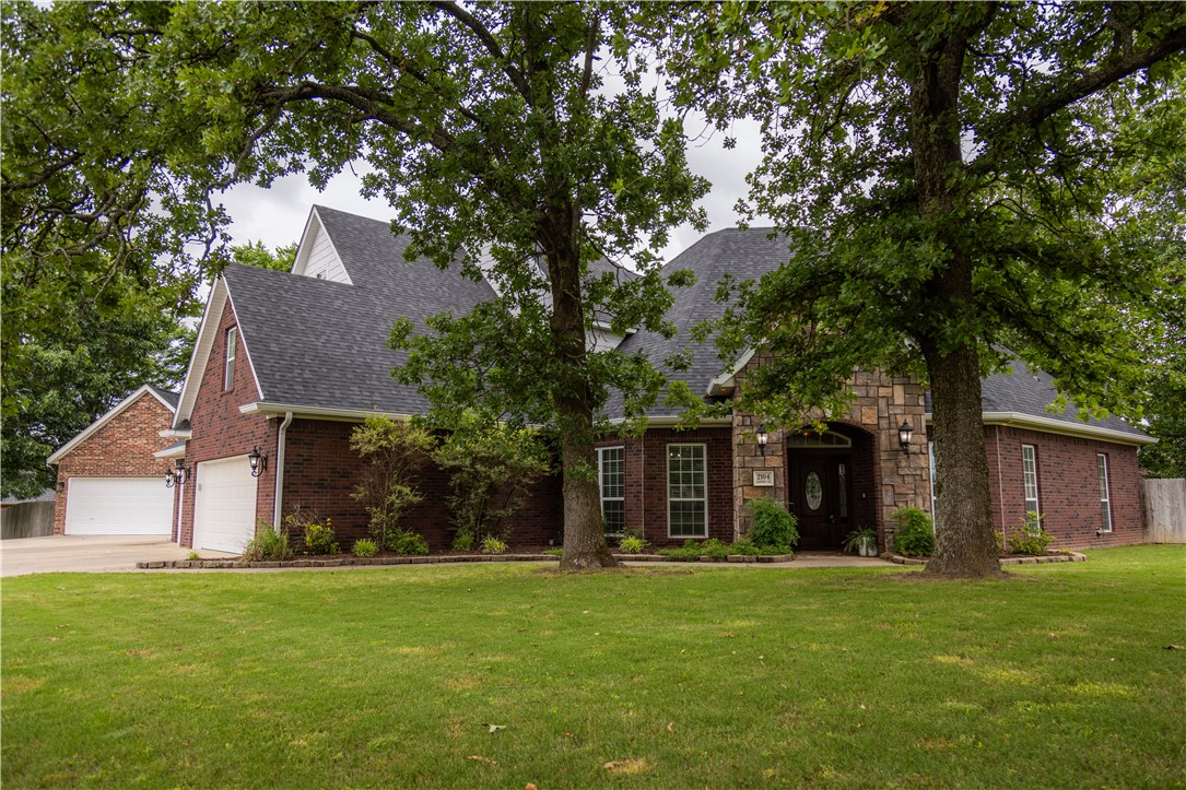 Newly renovated kitchen and primary bath! Recent updates include beautiful engineered hardwood flooring throughout the main living areas, a remodeled primary bath with new countertops and walk-in shower, and a stunning updated kitchen. This spacious 6-bedroom, 4-bath home sits on a scenic 1-acre corner lot in desirable Elm Springs, conveniently located between Fayetteville and Bentonville. The main level features a large primary suite with soaking tub and oversized walk-in closet, plus a second bedroom and full bath ideal for guests or multi-generational living. The inviting living room offers built-ins and a gas-log fireplace, along with a formal dining room and dedicated office. Upstairs you'll find four additional bedrooms, two full baths, a game room, and bonus room. Enjoy two patios overlooking the large fenced backyard, including one with a wood-burning fireplace. Attached 3-car garage plus detached 2-car garage with attic storage complete this exceptional property.