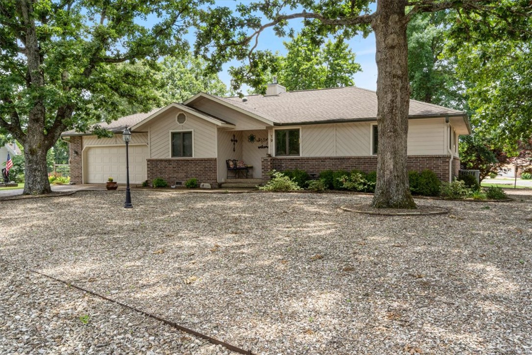 You've got to see this one! Charming 3-bed. 2-bath home situated on a spacious .59-acre double lot. Conveniently located near Highlands Golf Course and I-49, the property offers both comfort and accessibility. The kitchen features granite countertops, abundant storage, and a window overlooking the beautifully manicured backyard, complete with a concrete patio and firepit area-perfect for entertaining. A lovely sunroom at the back of the home provides additional living space, along with a covered back porch for enjoying the outdoors year-round. Plus, you'll never have to wait for hot water with home's instant hot water system.  Inside, the living room is centered around a beautiful wood burning fireplace that serves as a warm and inviting focal point. The main bedroom includes a stylish barn door leading into the main bath.
