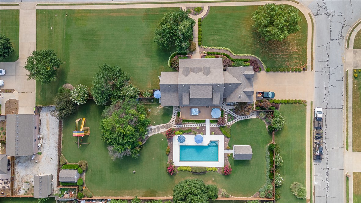 Outdoor entertaining and family gatherings become seamless in this spectacular property. Set on 1.12 professionally landscaped acres, this 3,598-square-foot home built in 2004 offers four bedrooms, two full baths, and two half baths, with outdoor amenities rarely found together on one property. The backyard features an inground pool, a jacuzzi on the large back deck, a custom steel-framed pavilion, a fire pit perfect for intimate gatherings, and a playground — a complete setup for entertaining and everyday use. The sunroom off the primary suite opens directly to a private dog run, making it ideal as a pet suite, hobby room, or flex space. The primary also includes two walk-in closets. A dedicated safe room adds security and storm protection. With a large yard, established landscaping, and generous square footage inside, this property combines practical features with genuine outdoor living space. Schedule a showing to walk the grounds and see the full layout in person.