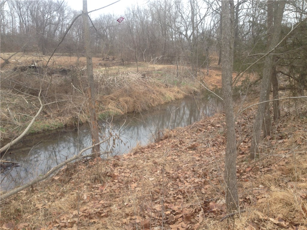 9.92 Acres with active stream. 1,344 sq ft shop near the highway has electricity, Perfect location to build your home at the top of the hill.