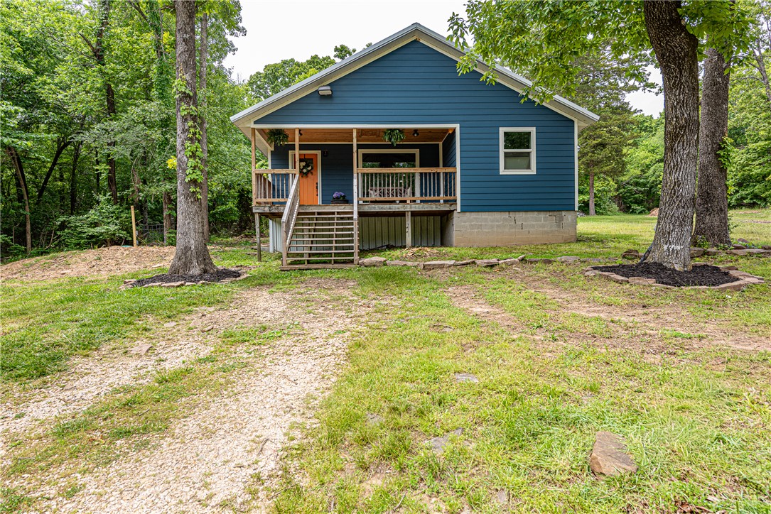 WELCOME HOME! This 3 bedroom 2 bathroom home on 2 acres +/ - is what you've been looking for to plant your roots! Located a short drive from Downtown Prairie Grove, City of Lincoln, I-49, & Fayetteville, this property offers both privacy & convenience. From the covered front deck head in to the living area w: vinyl plank floors, vaulted ceiling w/ wood detail & beams, large picture window, & wood stove! An eat in dining leads to the U-Shaped kitchen w/ butcher block counters, s.s appl, gas range, white apron sink, & stylish green cabinetry! A small flex space nearby perfect for coffee nook/ drop zone. Relax in the primary suite w/ private ensuite! Enjoy an addtl. two beds & one bath! Upstairs a loft space w/ vinyl plank floor, mini split, & closet for add’tl storage! Head out to the large partially cleared yard w/ mature trees,Shooting Range, & storage building offering plenty of room to enjoy the outdoors! Bonus - NEW Septic System! Act now!