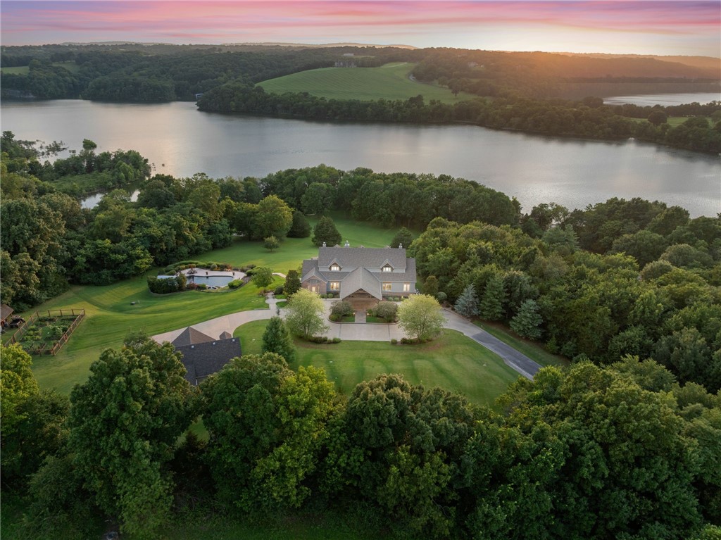 Discover your private lakeside sanctuary on the shores of Beaver Lake. Nestled behind a gated entry on over 10 acres, this stunning 6,300+ sqft estate offers the perfect blend of luxury, privacy, and natural beauty. A winding driveway leads you to an impressive custom-built home featuring expansive living spaces, soaring ceilings, and panoramic views of the surrounding landscape. Designed for entertaining and everyday comfort, the home has multiple living areas, a chef’s kitchen, and spacious bedrooms. Step outside to enjoy a resort-style inground pool, lush garden spaces, and serene lake access just steps away. The 3-car garage includes additional storage above—ideal for a studio, guest quarters, or workshop. Whether you're hosting summer gatherings or enjoying quiet evenings by the lake, this extraordinary property is a rare find on Beaver Lake. Welcome to your dream retreat.
