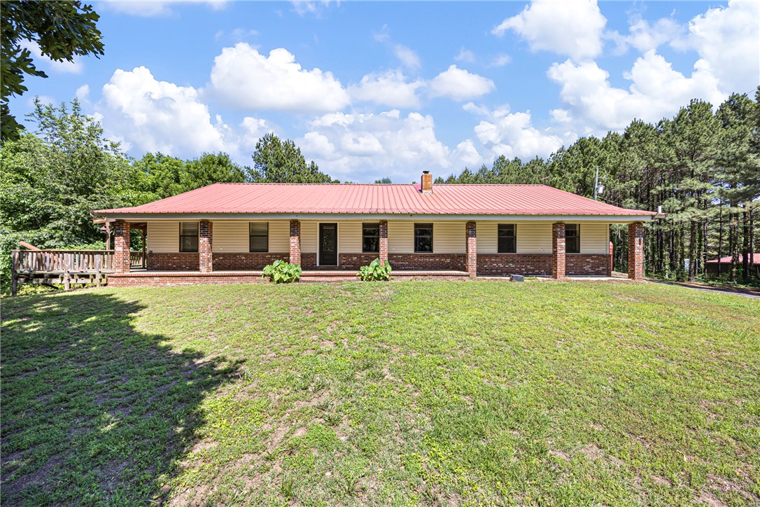 This custom-built brick home blends comfort, space, and functionality with wraparound decks, a metal roof, oversized 2-car garage, and additional 2-car carport. Inside, you’ll find custom cabinetry, expansive counter space, breakfast bar seating, stainless steel appliances, including a new ice machine, vaulted ceilings, and a spacious living room with a woodstove. The oversized primary suite features a newly installed bathtub and private access to the back deck.

Additional upgrades include a Rheem Prestige HVAC system and added attic insulation for year-round efficiency and comfort. Outside, the property features three large shops with endless potential for storage, business use, hobbies, or equipment space. The first shop is approximately 28x120 with 8 bays, the second is 40x60 with 3 deep bays and guest quarters ready for updating, and the third is a 40x70 shop with 4 bays, garage doors, a half bath, and a 20x40 drive-through wash bay. Mature pine trees planted over 23 years ago add beauty and potential value.