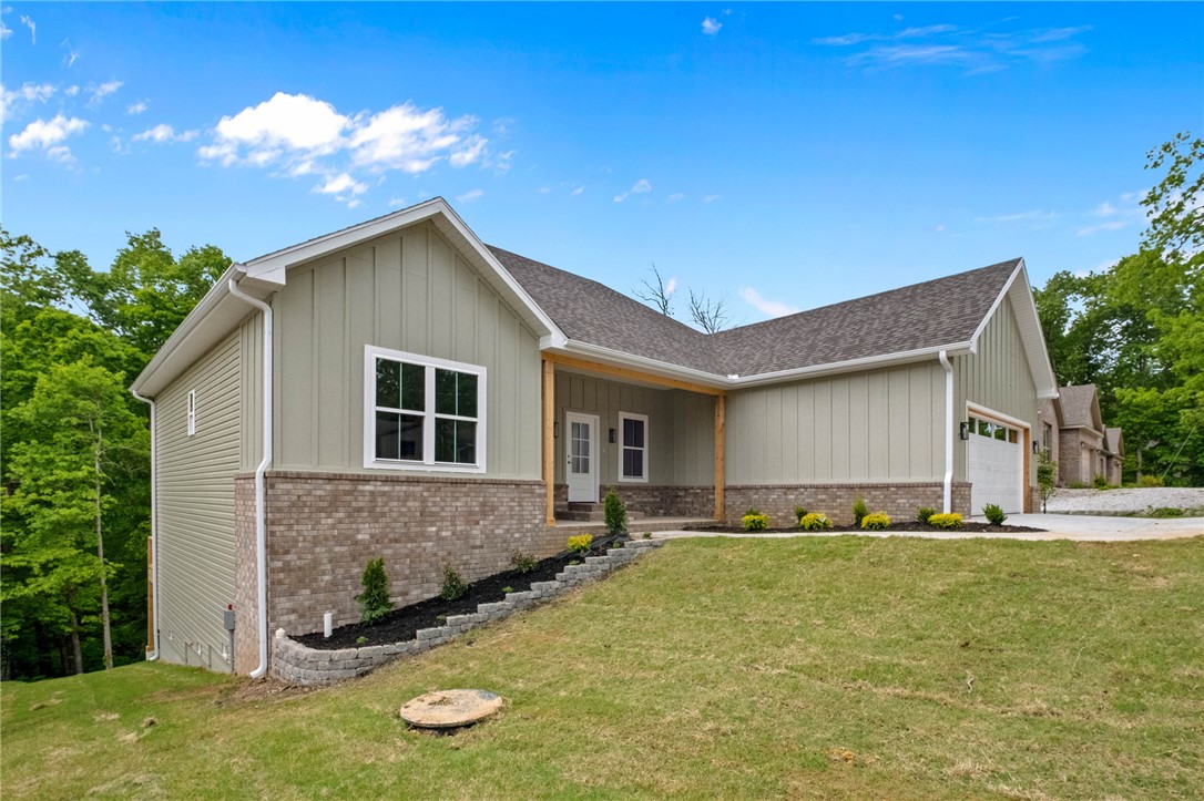 Brand-new construction in a quiet Bella Vista setting with modern finishes, clean lines, and a functional open layout. Light-filled living area, quality materials, covered front porch, and a level driveway leading to a two-car garage. Fresh sod and simple landscaping create a move-in-ready exterior. Located just 0.6 miles from nearby trail access via Hampstead Rd, offering quick entry to Bella Vista’s world-class biking and walking network. Enjoy wooded surroundings, nearby lakes, golf, and full POA amenities.