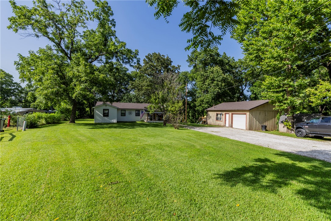 Welcome home: This updated home sits on almost an acre. Kitchen has with new faucet, sink, countertops, light fixtures, dishwasher and cookstove. New electrical panel, fresh painted interior. Added on a second full bathroom to the primary bedroom and 2 walk-in closets. New roof 2021, HVAC 2017. Fresh exterior paint on home. 2 car detached garage with workshop Approximately 496 SF. Home has glassed in sunroom on back not part of SQ Ft. Seller offering $3,000.00 buyer credit. Wow better hurry this one won't last long, Only minutes to  Rogers & Bentonville