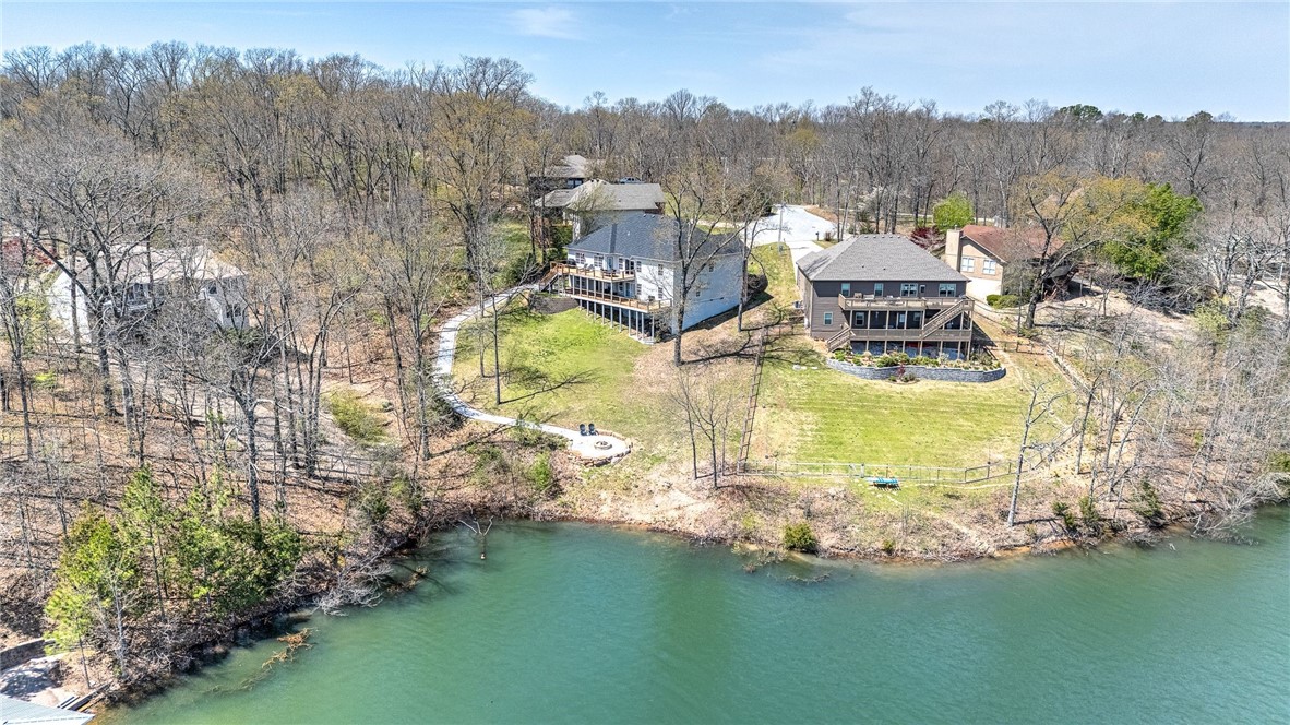 Welcome to your own slice of lakefront paradise on beautiful Lake Brittany in Bella Vista. This 5-bedroom,  3-bath home offers the perfect blend of relaxation and functionality with lake access directly from the property—just steps to the water for kayaking, fishing, or simply soaking in the view. Designed for comfort and flexibility, the home features two full kitchens, 2 living rooms, and 2 laundry rooms. Fantastic layout, ideal for guests, entertaining, or multi-generational living. Step outside to enjoy two expansive decks overlooking the lake, perfect for outdoor dining, morning coffee, or evening gatherings. Recent upgrades include a new AC unit March 2025 and a septic system pumped in 2024, giving you peace of mind and move-in readiness. Fenced in dog yard in the back! There's also a cozy outdoor fire pit—just one more way to enjoy the tranquil surroundings. With a strong short-term rental history, this property offers excellent income potential as well. Come see what lake life could look like for you!