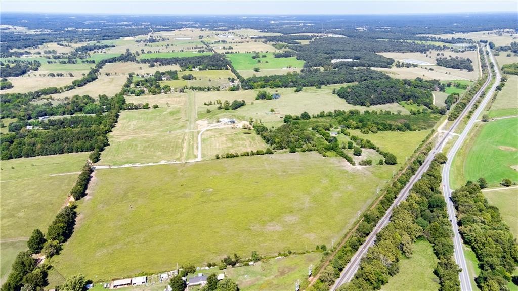 Exceptional opportunity to own approximately 53 acres of versatile industrial/mixed-use land in a prime Northwest Arkansas location. This property offers outstanding accessibility with frontage on Hwy 59, Railroad Lane, and Winningham Road, providing excellent visibility and multiple access points ideal for development, investment, or agricultural use.

The property includes a charming farmhouse full of potential that could be restored with updates, offering the opportunity for a primary residence, rental, or operational headquarters. With ample open space and flexible land use, the property is well suited for a horse ranch, hobby farm, or agricultural operation.

Conveniently located near McKee Foods and minutes from Gentry’s downtown revitalization area, the property is positioned in a growing corridor with strong future potential. Utilities including water and electric are available at the street, with sewer nearby, providing flexibility for a variety of uses.