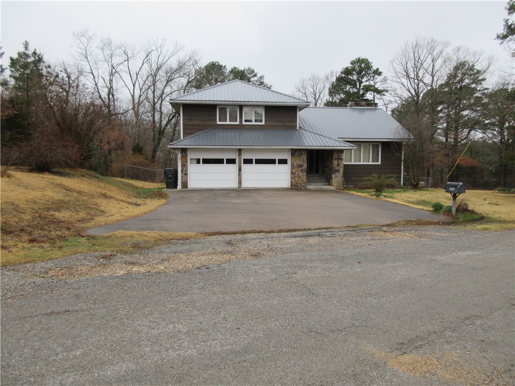 Well-designed split-level home with a sunken dining area, kitchen, and family room. Sitting in a park-like setting and just out of the city limits, with a 2-car attached garage and an oversized one-car garage that features a shop area. Two native stone fireplaces - one propane and one wood burning. All furnishings convey with the property. Recent upgrades: installed a new Anderson sliding double-glass door from the kitchen to the backyard, new steps, and a new compressor and blower motor for the HVAC unit. The seller is currently connected to the Common Sense Cellular wifi tower.
