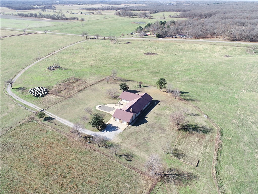 Just a short drive from Bentonville is the escape to your sanctuary with this stunning remodeled country estate, blending luxurious living with the functionality of a small hobby farm. This magnificent 3,811 square foot home sits on 22 acres of prime pastureland and is designed with a split floor plan that ensures ultimate privacy. It boasts the two expansive master suites where additional bedrooms could be added with two separate living areas, offering exceptional flexibility for multi-generational living or grand entertaining. Every corner of the house has been updated and modernized, providing a move-in ready home.  Outside, the property is an oasis with a large patio that overlooks the pasture and features a refreshing in-ground pool. For the ranch enthusiast, the 22 acres include a corral and existing fencing, creating an ideal setup for a hobby farm, horses, or other livestock. The property is completed by a substantial 40x40 shop, making this a rare, turnkey opportunity for luxurious country living.