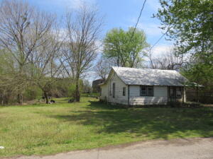 Potential unlimited!  VISIONARY with a strong work ethic needed. Double city lots. Home of yesteryear is in a state of remodel. No kitchen flooring.(PRIVATE REMARKS) Home does have a metal roof, large living room, remodeled bathroom, and a bonus room that could be an office, nursery, etc. BRAND NEW WINDOWS HAVE BEEN PURCHASED for the house.  A large window system that is stored in the living room does not convey with this home. Please enter the home with caution as is currently in a state of remodel. See Private Remarks.  Sells as is condition.