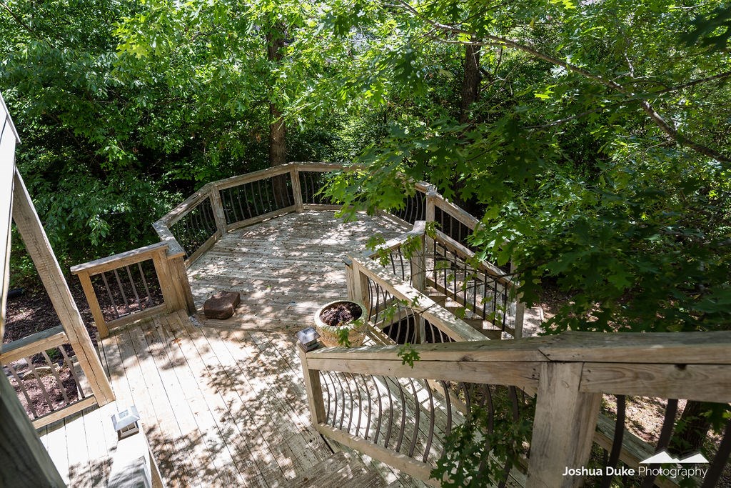 CUSTOM HOME 10 MIN SOUTH FAYETTEVILLE. Treetop Deck. Upgrades include 3/4" white oak hardwood floors (no carpet), large open & split floorplan, kitchen, dining, living with 16" vaulted ceilings. Custom cabinetry, built-in headboard in master, architectural millwork, custom doors, custom lighting. On-demand gas water heaters for efficiency. Dead-end, quiet subdivision, 1300+ s/f of decks - upper, lower, and octagonal.  Landscaped, custom brick work & tile inlay at entry. Both attic & crawl space insulated.