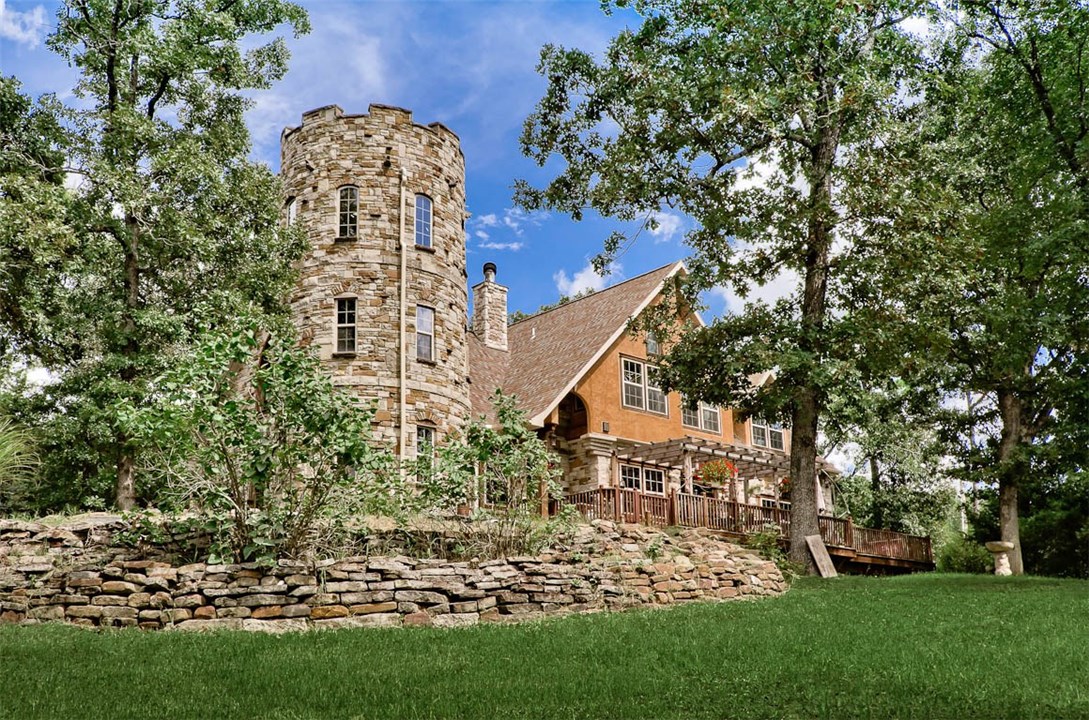 Unique Arts & Crafts style home with spectacular views of the Ozark Mountains. 3 story stone castle turret with observation deck on the roof.  Wonderful vaulted ceilings with hand-made limestone fireplace bring the warmth into the space. Open floor plan with circular dining room leading onto a private deck. Pumpkin Pine floors greet you in the spacious foyer with open staircase leading to the second floor. 2 master bedrooms, bonus room, large deck, and gorgeous stone patio with fire pit.