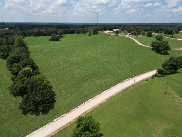 Beautiful 61-acre rolling property fully equipped for livestock operations and ready for your dream home. Features a complete working setup with multiple feedlots, a large covered feeding and vet barn, and a well-designed working corral. Includes a spacious shop with feed storage, plus a stacking shed for grain and bedding. Utilities are in place with an existing septic system, rural water, and electric already set up. Enjoy stunning views from the elevated homesite. Conveniently located just 10 miles from XNA and 20 miles to the Walmart campus, offering the perfect blend of rural functionality and accessibility.