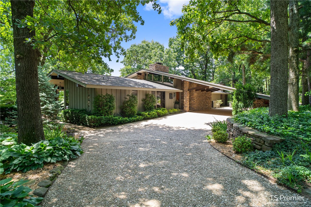 A Mid-Century modern designed home leaves nothing to be desired. Architects were Witherspoon & Smart, Witherspoon was an associate in practice with his longtime colleague E. Faye Jones whose construction crew built the home. This notable home features native Arkansas stone floors, fireplaces & master shower. Mahogany wood in the home creates a warm luxurious feeling and has been refinished and shows remarkably. The maintenance and upgrades are impeccable, extensive landscape, tankless water heaters, 2 generators, all glass in the home has been replaced and with its ceiling to floor windows across the back, you feel as though you are living outdoors with stellar views all the way to Old Main!  The kitchen remodel brings it into the 21st century yet keeps the integrity of its original design.The majority of property is fully sustained with external solar panel power. The guest house continues with the mid-century design of the main home. A prestigious property that will surely cater to the discriminating few.