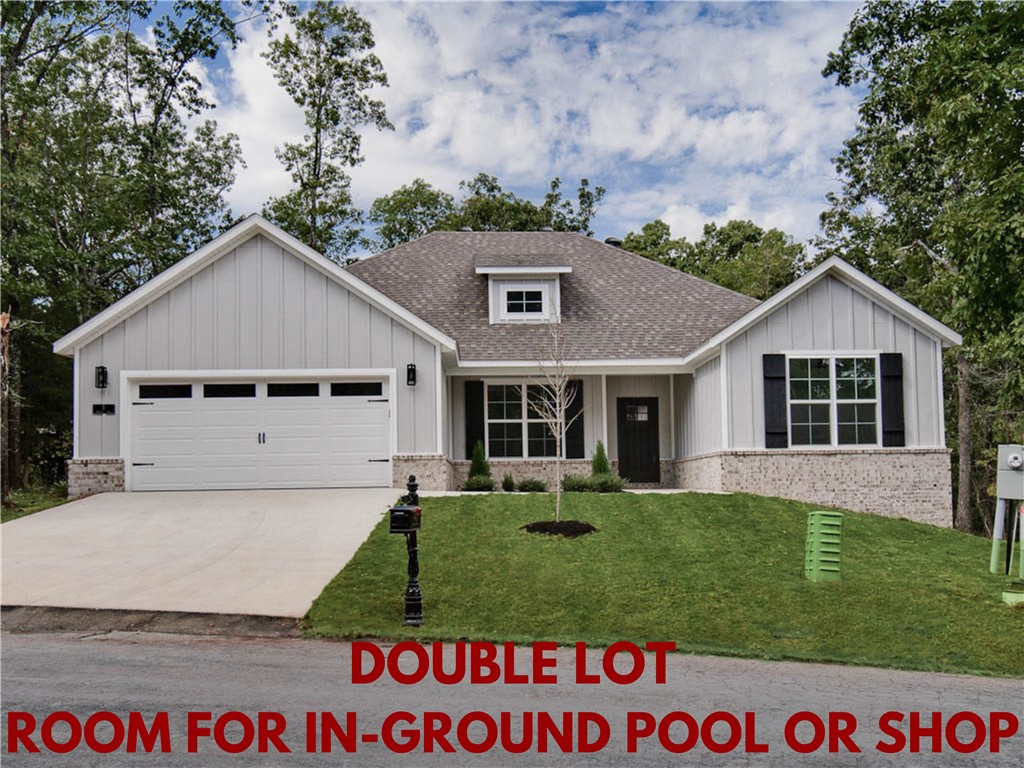 Stunning new construction home on a .57 acre wooded double lot! Plenty of room for a shop or an in-ground pool! Perfectly situated down the street from the Lake Loch Lomond boat dock and provides easy access to Highlands Golf Course, trails, and I-49! Step inside to discover a beautifully designed interior with 3BD's + office, a split floor plan, & high-end modern finishes throughout. NO CARPET! The spacious living area showcases vaulted ceilings with elegant beams, creating an inviting atmosphere. The kitchen features sleek 3 cm quartz countertops, a gas range, island, and beautiful custom cabinets. Retreat to the luxurious primary bath, which boasts a huge walk-in closet, a large custom walk-in tile shower, and a soaking tub. 2 covered patios. As an added bonus, receive $3,500 towards buyer's closing costs when working with the builder’s preferred local lender!