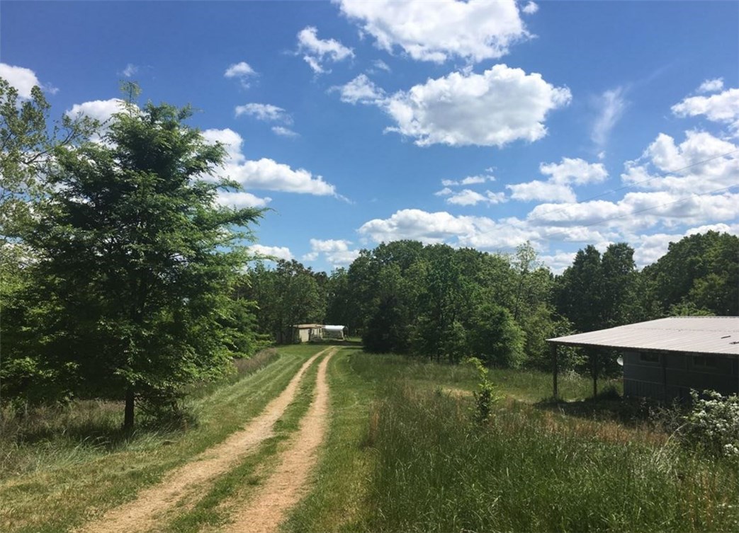 1440 Sqft Double Wide on 3.3 Acres, 9 1/2 Miles NW of Rogers, Has nice setting with a large covered lean to length of the home. 4 bedroom, 2 bathroom Central air.