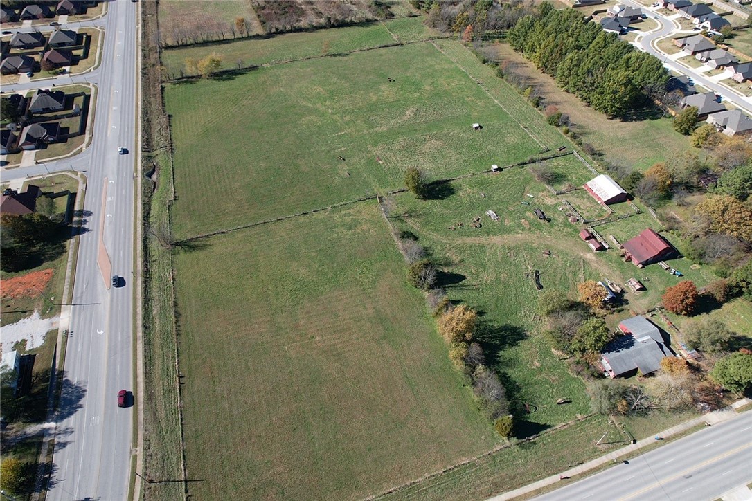 Development potential!  This was formerly 20 acres of farmland that is now about 18.09AC MOL due to the building of Don Tyson and widening of Butterfield Coach.  It's flat and level.  Currently zoned AG but Springdale future use shows it as "Low Density Residential" and the inside corner as "Neighborhood Commercial." The value is in the land, but there's an approx. 2000 sq. ft. house on the property and some other buildings/barns.  The seller will need some time to remove the farming equipment.   (NR Deposit required before the seller will begin to move anything.)  Call listing agent with any questions.     It's being sold as is.  (Seller still lives on property...please do not disturb them and there will be no showings of the house or other structures really...just the land)