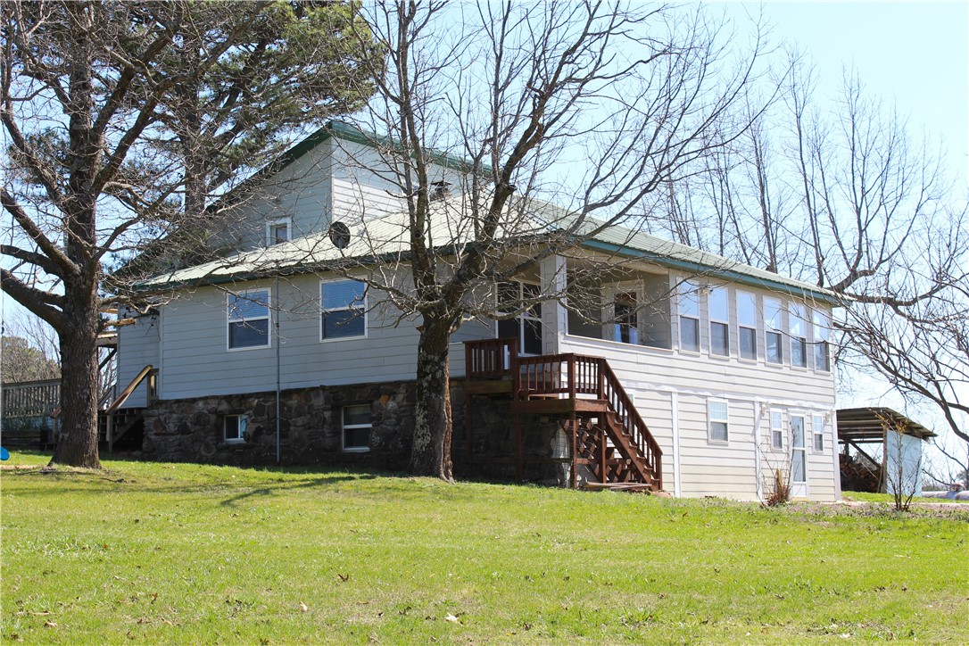 Positioned on 4.5 acres in the Arkansas Ozarks, this multi-home property offers immediate potential for rental income or short-term rental use in a high-demand recreation area. Located minutes from Kings River and Beaver Lake, and a short drive to Eureka Springs, the property benefits from consistent tourism, fishing, and boating activity year-round.

The 3,400 sq ft main home features 3–4 bedrooms, 3 baths, expansive living areas, custom kitchen, private loft, walk-out basement, wood stove heat, generator backup, and wraparound decks overlooking a pond.

Additional improvements include a 3BR guesthouse and 1BR cabin, allowing for multiple income streams or flexible living arrangements. A barn with utilities, fenced areas, and garden space add functionality.

Convenient to Berryville and near Trigger Gap Airstrip.  Property listed with additional acreage MLS 1339168