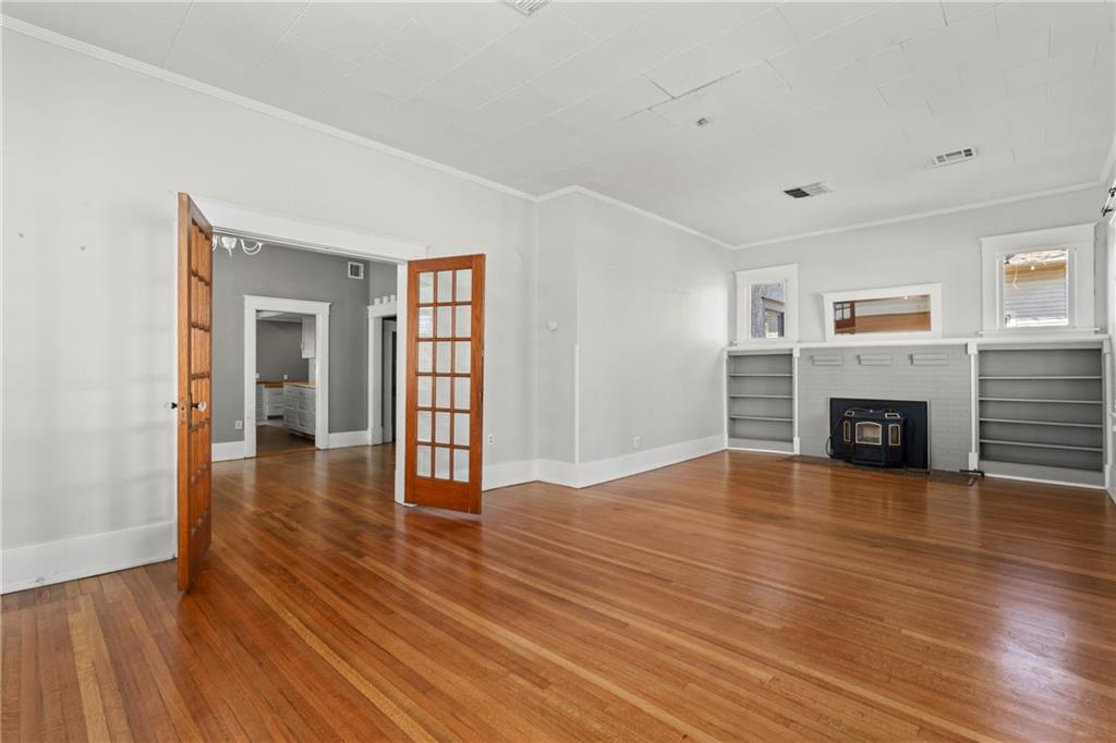 This turn of the century, historic home, originally built in 1903, has been updated with beautifully restored original hardwood floors, new vinyl plank flooring, fresh paint, new bathrooms, new kitchen, new AC, all new ducting, new hot water heater, new porch columns,  plus each bedroom has its own coded lock- perfectly setup for Airbnb/VRBO/ boarding house, Furnished Finder. With large rooms all throughout, it would make an incredible family home or investment property/ rental. The upstairs suite features 363.6 Sq. Ft. with its own private full bath. Enjoy the large, covered front porch, and the peace of mind of having a cellar/ storm shelter with inside access. Located in the heart of downtown Siloam springs just steps away from the Memorial Park Chautauqua Amphitheater/ splash pad/ Farmer's Market and all downtown Siloam has to offer. Yard is fully fenced with new privacy fencing, but a section was removed to add additional parking off the alley (materials on site,  can be reinstalled if desired).