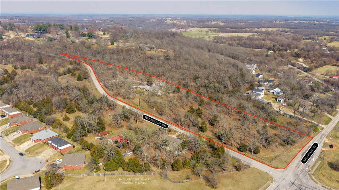Rare opportunity to own 7.27 acres in Springdale offering privacy, functionality, and convenience. Positioned on a corner at Woodcliff Rd. and Monitor Rd., this property features scenic bluffs along the eastern boundary. The land is currently fully fenced with durable iron fencing and includes two barns on concrete pads with electricity and water already run to the buildings. With excellent road frontage and easy access to town, this property is ideal for all. The property is just minutes from downtown Springdale, with quick access to J.B. Hunt Park, Murphy Park, Luther George Park, and Lake Springdale. Enjoy nearby access to the Razorback Greenway, as well as convenient connections to US-412, Hwy 249, and I-49. Experience the perfect balance of peaceful acreage living with close proximity to parks, recreation, dining, and everyday amenities.