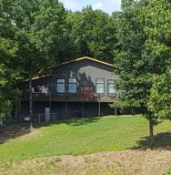 Rustic home with high vaulted ceilings, whole house generator, and loft located in beautiful setting. Interior is Western Cedar Timber frame and exterior is Duralock siding. Breezeway to double garage. Split level heating using electric and gas. Home features hardwood floors, large windows overlooking covered deck and property. The 3rd BR is located in the basement and could easily be used as office or music room. Main floor bedrooms have their own bathrooms. Open floor plan combining kitchen, dining room, and living room. Large covered deck made from Trex material on back of the house. Extras: Metal building with concrete floors 16x24, pigeon and chicken coops 16x24,  greenhouse 6x14, landscaping, vineyard, high speed internet (fiber optic)