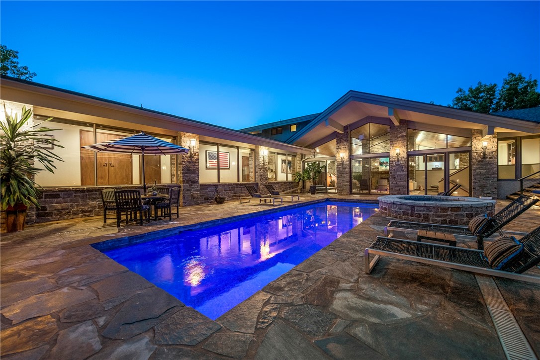 Incredible Prairie-Style Frank Lloyd Wright inspired custom home with amazing backyard oasis. This architecturally significant home stays true to form; unassuming on the front, blending into Mother Nature with massive walls of glass overlooking the flagstone pool, layers of outdoor space and the manicured grounds. True FLW style all the way, even down to the "salute to wheat" hidden in the cathedral glass window of the great room. This home has a vibe like no other, perfect for entertaining or simply relaxing. Life seamlessly flows from indoor to outdoor space. There are so many great nooks and crannies to explore. The current owners have just completed a massive overhaul of the outdoor space. It includes an alfresco dining area with a 20'x8' natural edge pecan table with fire feature. Imagine the memories that can me made around this marvelous table. Inside you will love how the house flows.  Several smart home features including whole home lighting and audio. This is a home made to enjoy life.