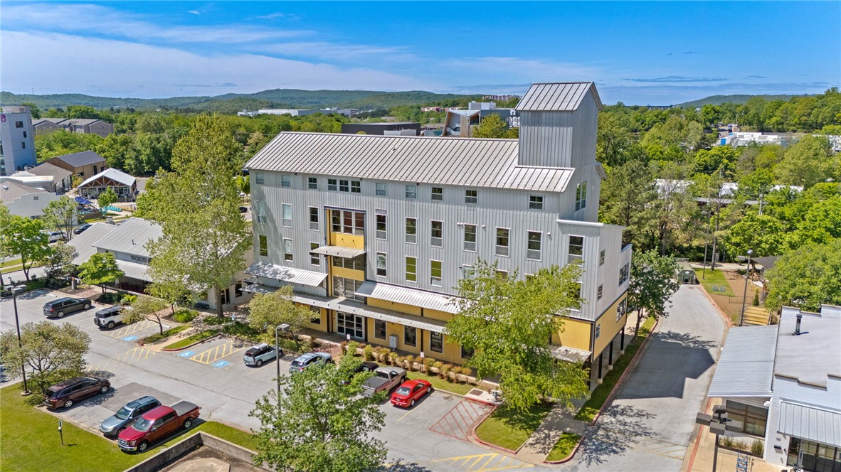 Experience a piece of Fayetteville’s history in this classic loft style condo. Once a 1950s feed mill, this landmark building has been reimagined as the heart of the Mill District. This rare 1,356 sq ft, two-bedroom loft is all about character. The interior keeps the original spirit of the building with soaring ceilings, exposed metal beams, and polished concrete floors that keep the space feeling open and simple. The main floor features a wide-open layout where the kitchen, dining, and living areas flow together naturally. Upstairs, the expanded floor plan offers extra room and privacy while maintaining the building's iconic, airy feel. Perfectly positioned on the Razorback Greenway, you’re just steps from the Lower Ramble, Cultural Arts Corridor, and the Entertainment District.This prime location offers immediate access to the dining and entertainment of South Yard, The Mill, and Prairie St placing the best of downtown Fayetteville right at your doorstep.