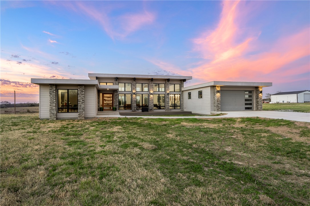 Experience refined open-concept living in this stunning modern home set on just under 10 acres, offering the perfect blend of contemporary design, comfort, &  peaceful privacy. Flooded with natural light, the airy layout seamlessly connects the main living, dining, & kitchen spaces, creating an ideal setting for everyday living & entertaining. The gourmet kitchen serves as the heart of the home with premium Bosch appliances, sleek modern finishes, & generous gathering space.

Enjoy effortless indoor-outdoor living with an inviting front patio & expansive covered back deck overlooking the surrounding landscape. The luxurious primary suite feels like a private spa retreat, featuring a state-of-the-art walk-in shower & oversized two-person soaking tub.

Flexible bonus space offers endless options for a home office, media room, playroom, or creative studio, while the large metal workshop provides space for hobbies, equipment, or storage. Modern style, open spaces, and room to breathe—this property truly has it all.