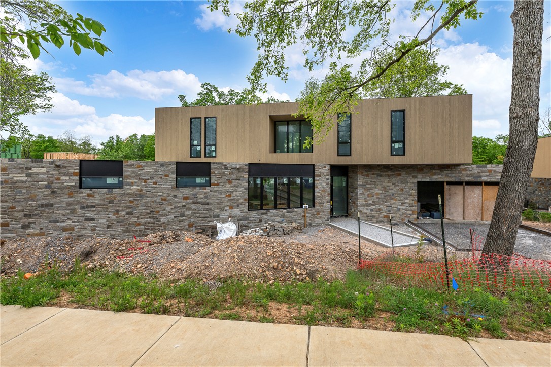 A refined expression of Ozark modernism, this architecturally significant residence in Nelagoney Glen draws inspiration from Frank Lloyd Wright, blending natural materials with intentional design. Rich walnut cabinetry anchors a sophisticated forest-inspired palette, creating warmth, depth, and understated luxury throughout. Clean lines, expansive glass, and seamless indoor-outdoor flow invite the surrounding landscape in, offering a sense of calm and privacy just minutes from downtown Bentonville. Designed by Modus Studio, every detail reflects craftsmanship and purpose—from curated finishes to the harmonious connection with nature. A rare opportunity to own a home where architecture, setting, and lifestyle converge at the highest level. This home will be ready in July. Renderings are conceptual and may vary from final construction. Images shown are from the model residence and are intended to represent the level of design, craftsmanship, and finishes to be delivered in this luxury home.