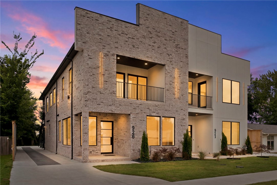 Welcome to effortless modern living in the heart of Bentonville. This newly built townhouse blends exceptional craftsmanship with thoughtful design, offering 4 spacious bedrooms and 3.5 baths—including two primary suites ideal for co-living, guests, or multi-generational families. The gourmet kitchen impresses with high-end appliances, sleek cabinetry, and ample counter space, while a bonus kitchenette adds everyday convenience. An open-concept layout is bathed in natural light from oversized windows, creating a bright, inviting atmosphere throughout the main living areas. Step outside to a large covered patio, perfect for relaxing or entertaining, rain or shine. Just steps from 8th Street Market, Thaden School, and the Walmart Home Office campus, this home puts you at the center of Bentonville's vibrant energy. From premium finishes to a smart, flexible floor plan, every detail reflects quality and comfort. If you're seeking space, style, and an unbeatable location, this one checks every box.
