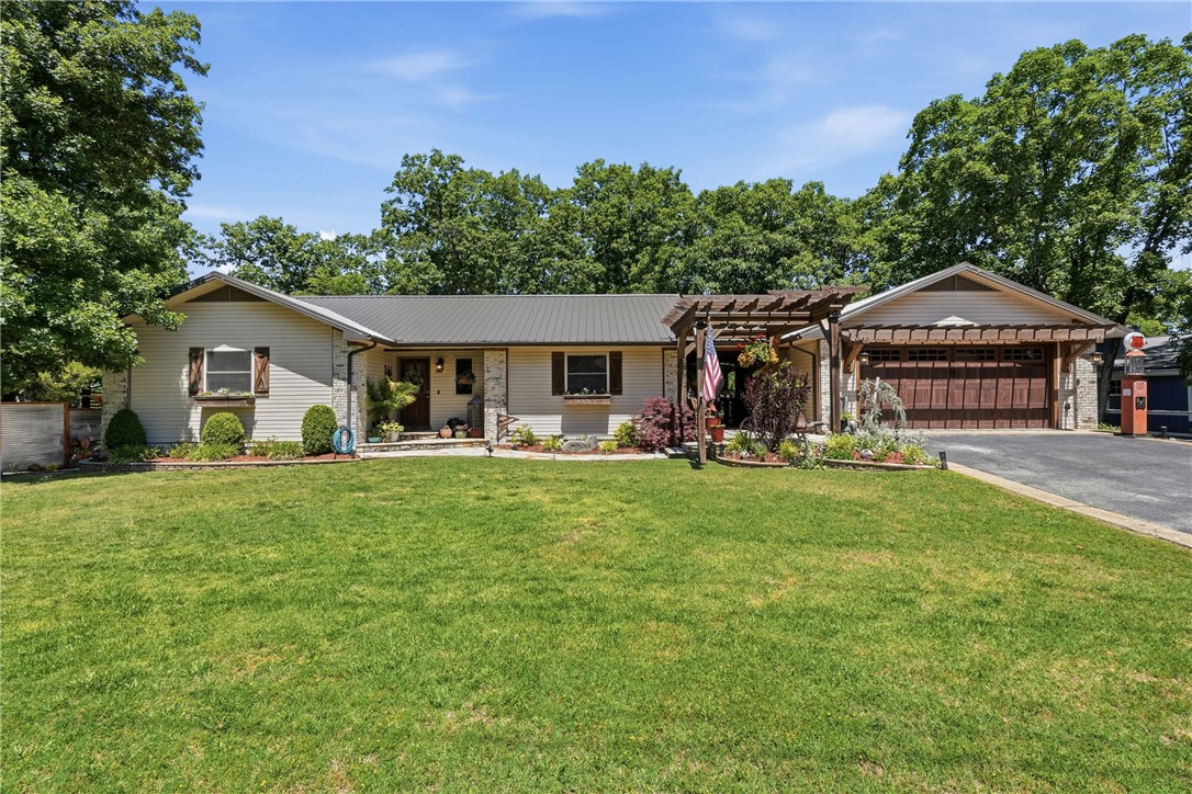 Completely remodeled with character, charm, & functionality in every space, this 3-bedroom, 2.5-bathroom home checks every box! Conveniently located next to the Holiday Island Country Club & just minutes from golf, groceries, & restaurants. The main level features beautiful lighting throughout, vaulted ceilings with wood beam accents, decorative wall panels, open-concept living, formal dining, flex space perfect for an office, & a main-level ensuite bedroom. The stunning kitchen offers custom cabinetry, quartzite countertops, a large island with seating, & a hidden butler’s pantry with extra storage, sink, & butcher block counters. Downstairs features a fully finished walkout basement with a second living/sitting area, 2 bedrooms, full bathroom, laundry room, & additional storage space. Enjoy multiple outdoor hangout spaces including a huge covered upper deck, side deck, & lower flagstone patio with stone fireplace. Heated/cooled garage with a 512 sq ft workshop, & detached carport complete this one-of-a-kind home.