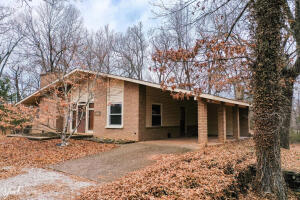All brick custom home on 7.75 acres located just 2 miles from Johnny Morris's new development and just minutes from the Buffalo National River, your recreation choices are endless. Upon entry, you will love the native stone floor and locally harvested wood on the stairwell. The living room and bedroom in the basement have wood burning fireplaces for that rustic feel. The house is heated and cooled by a geothermal unit and also has a whole house generator in case the power goes out. The covered deck measures 30x12 and is a perfect place for relaxing in the peacefulness or for that outdoor bbq'er. There is also a 30x32 insulated shop with electric. With some clearing, there would be a gorgeous view from the front yard. Make this your forever home or nightly rental.