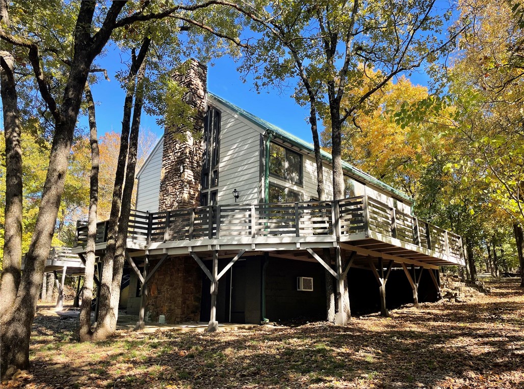 This beautiful, unique 5 bedroom house has so many opportunities for a buyer.  It would be an excellent Airbnb property, private home in the woods, a get-away cabin, pad for university students, and a rental property.  It has three separate living areas with exterior access that can be sectioned off from the others giving the owner many rental options.  Exhibiting 22.5' cathedral ceilings in the main living room, a loft overlooking and 1100sqft wrap-around wood deck, this house is perfect for hosting company. Many upgrades including granite countertops, newer metal roof, brand new 'Hardie' permanent siding, recently tiled showers and freshly painted.  Agent Owned.