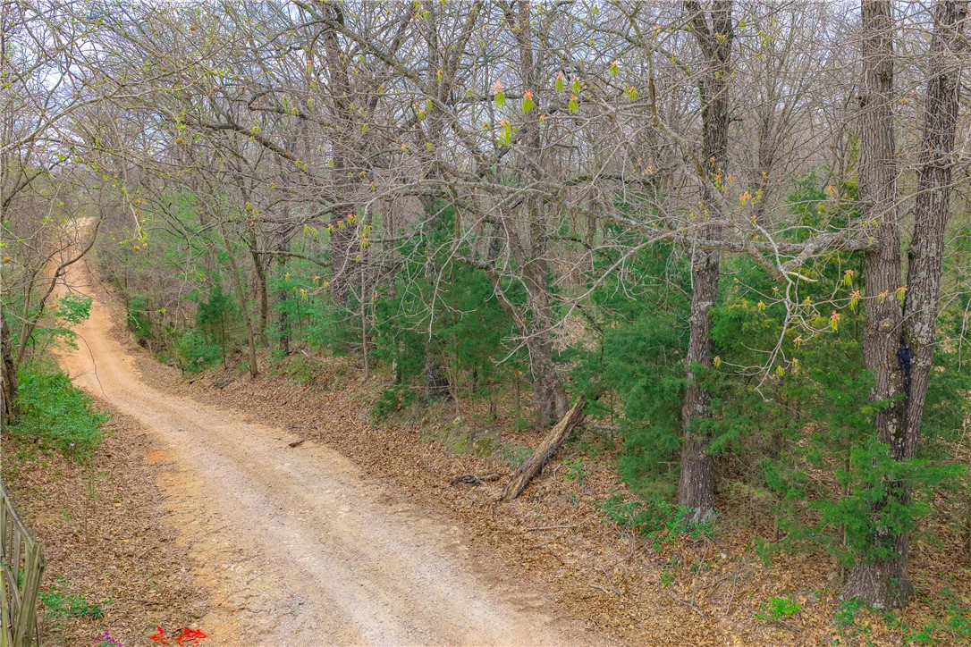 Tired of neighbors who "borrow" your stuff and never return it? Say hello to your own 19.75-acre wooded sanctuary on Arkie Rd in Rogers! This level, heavily wooded retreat is practically begging for your RV, mobile home, or dream build — and the best part? The hard work is already done. Public water and an existing on-site septic are ready and waiting, so you can literally roll in and start living. Electric is at the street, paved road access makes it easy to find, and no covenants means nobody's telling you what to do. At $295,000 with Rogers schools and taxes of just $27 a year (yes, you read that right), this is your chance to own a private slice of NW Arkansas before someone else does. Call today!