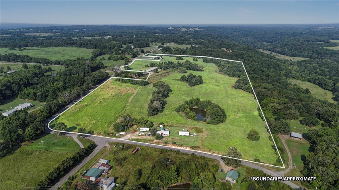 This exceptional 62-acre property features rolling terrain of mature woods and open pastureland. Strategically positioned on a corner lot.  Four scenic ponds and a running creek dot the landscape.  The varied topography and natural beauty make this land ideal for multiple uses - from recreational pursuits and potential agricultural ventures to subdivision possibilities for residential development.  The property currently features a cozy 1-bedroom main residence with 951 square feet of thoughtfully converted living space, and an additional 450-square-foot converted utility building added for space.  The combination of premium location, diverse natural features, existing infrastructure, and substantial acreage creates numerous opportunities for investors, developers, or those seeking a private estate with income potential. The corner positioning enhances accessibility while the water features and varied terrain add significant value for any intended use.