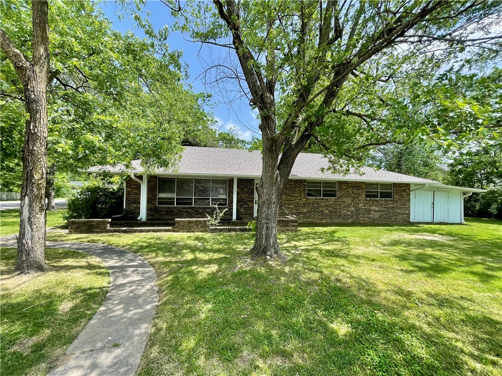 Located in the heart of town, this inviting home offers space, convenience, and charm all in one package. Featuring 3 bedrooms, 2 bathrooms, and a 2-car garage, the home includes two separate living areas, one with a cozy fireplace, providing flexibility for entertaining, relaxing, or everyday living. The kitchen includes a dining area with easy flow for meals and gatherings. Additional highlights include an attached workshop ideal for hobbies, storage, or projects, plus a desirable corner lot with mature trees, welcoming front porch, and back patio for outdoor enjoyment. Conveniently located near Murphy Park, the library, aquatic center, restaurants, shopping, and more, this property offers easy access to everything you need. With its versatile layout, this home provides plenty of room to grow and adapt to your needs. The combination of indoor and outdoor living spaces makes it easy to host gatherings or simply enjoy evenings at home.