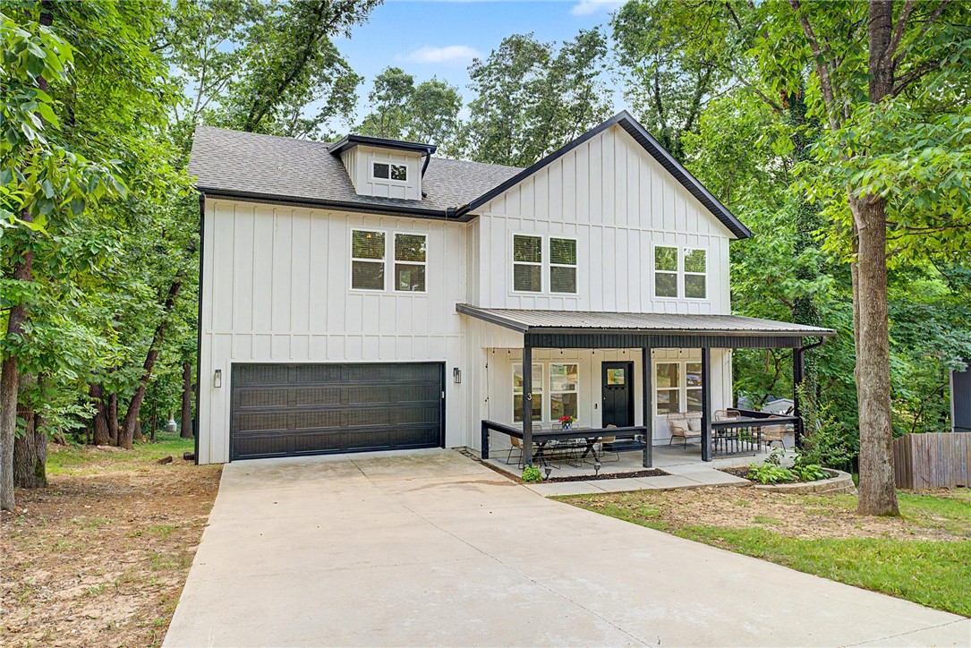 Nestled among the rolling woods of Bella Vista, this like-new home boasts a warm traditional style. Ideally located within a quick bike ride to the Tweety Bird and Tunnel Vision trail and just minutes from the new OZ Trails Bike Park and lift, this property is perfectly positioned for outdoor enthusiasts. The thoughtfully designed layout features the main living area, kitchen, and half bath on the first level, creating an inviting space for everyday living. Upstairs, all bedrooms are situated alongside two full bathrooms and a versatile landing area ideal for a reading nook or workspace. Outdoor living shines with a charming covered front porch accented by a metal roof and a spacious back deck surrounded by natural scenery. Convenient access to Bella Vista’s lakes, golf courses, trails, recreation centers, and nearby Bentonville amenities provides an exceptional location to everything that makes Northwest Arkansas special. Home is deeded as a 2-bed septic, and acknowledgement of this must be in offers.