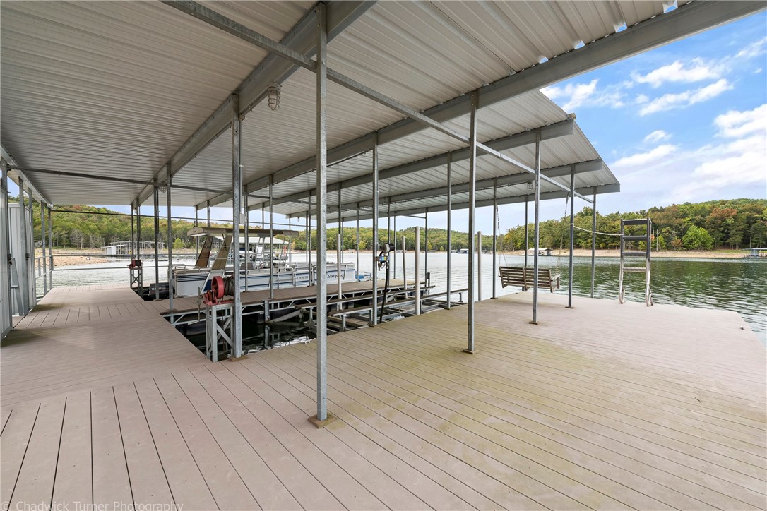PRIVATE 2 SLIP DOCK WITH ONE LIFT AND SWIM DECK! Thirty-foot slips. Record size stripers have been caught in this treasured cove. Level, yes I said LEVEL easy walk to the water. This is the home you are dreaming of! Perfect for Momma on the inside, and the dock of Dad's dreams on the outside. Want to fish at night? Just turn on your trail lights for an easy, safe walk to the dock. Spacious airy comfortable inviting rooms; new flooring, paint, and decking.  Large Screened porch off master that has a commanding view of the cove. Beautiful land w/ beautiful homes on beautiful lake. Come get you some.