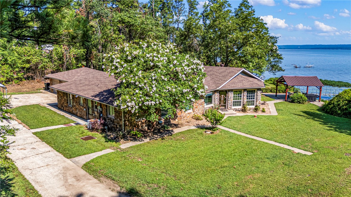 Tucked away along the shoreline of Lake Dardanelle, this waterfront retreat offers privacy, natural beauty, and direct access to one of Arkansas' premier lakes. Featuring 3 bedrooms, 2 full baths, and just over 2,000 sq. ft. of living space, this home sits on 1.5 acres and is designed to embrace the peaceful lakeside setting. Enjoy a private dock with two boat slips, a newly updated patio overlooking the water, RV hookup, and a recently installed roof. Whether you're fishing, boating, entertaining, or simply enjoying the view, this property offers the perfect blend of comfort, convenience, and waterfront living.